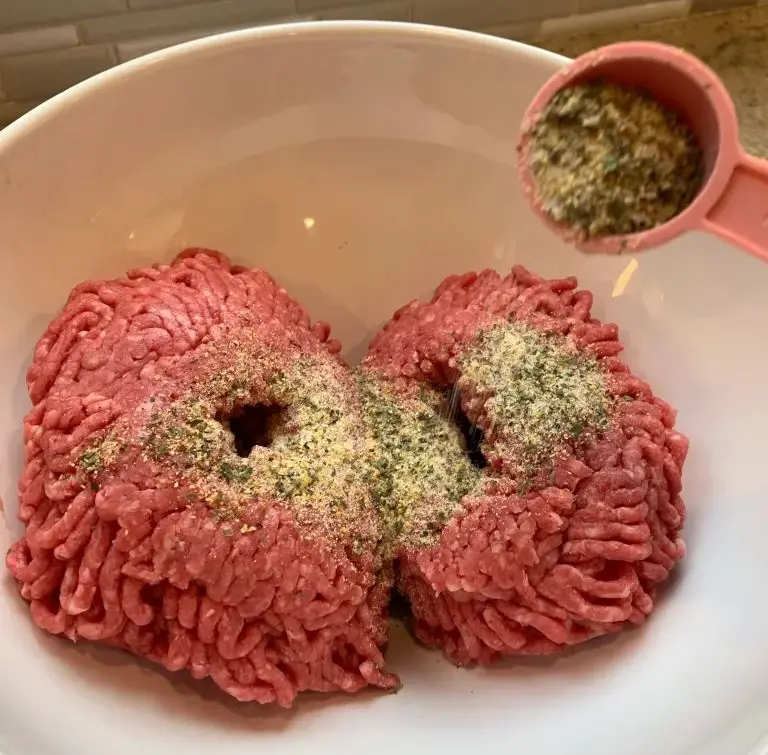 adding seasoning to the ground beef