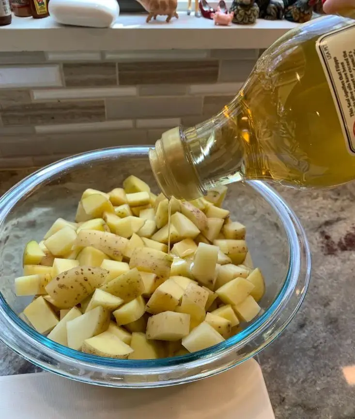 adding olive oil to potatoes
