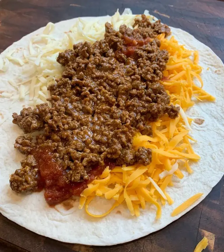 taco seasoned ground beef on top of shredded cheese and salsa