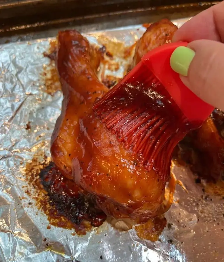 brushing bbq sauce on chicken