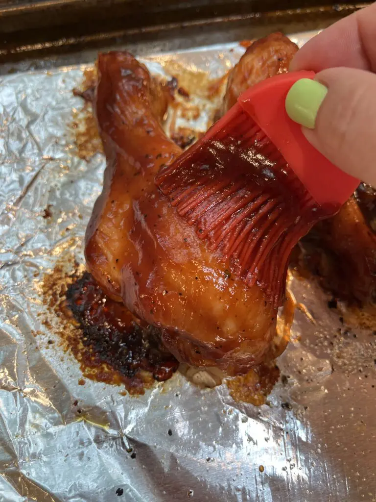 brushing bbq sauce on drumsticks