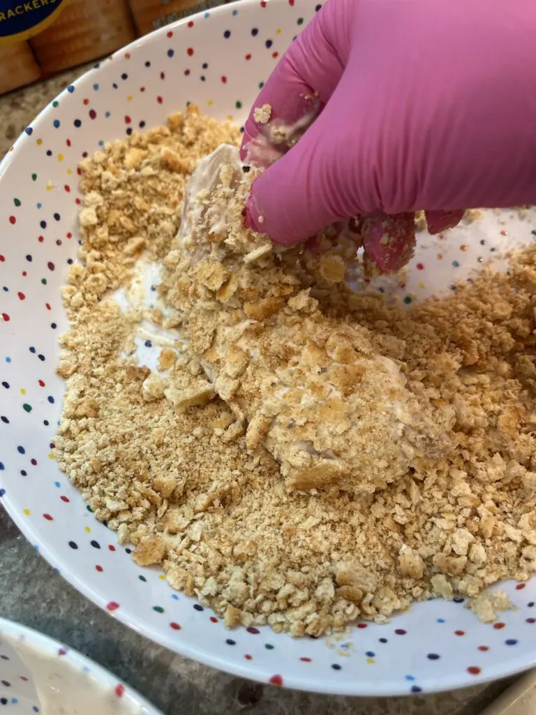 dipping chicken into ritz crackers