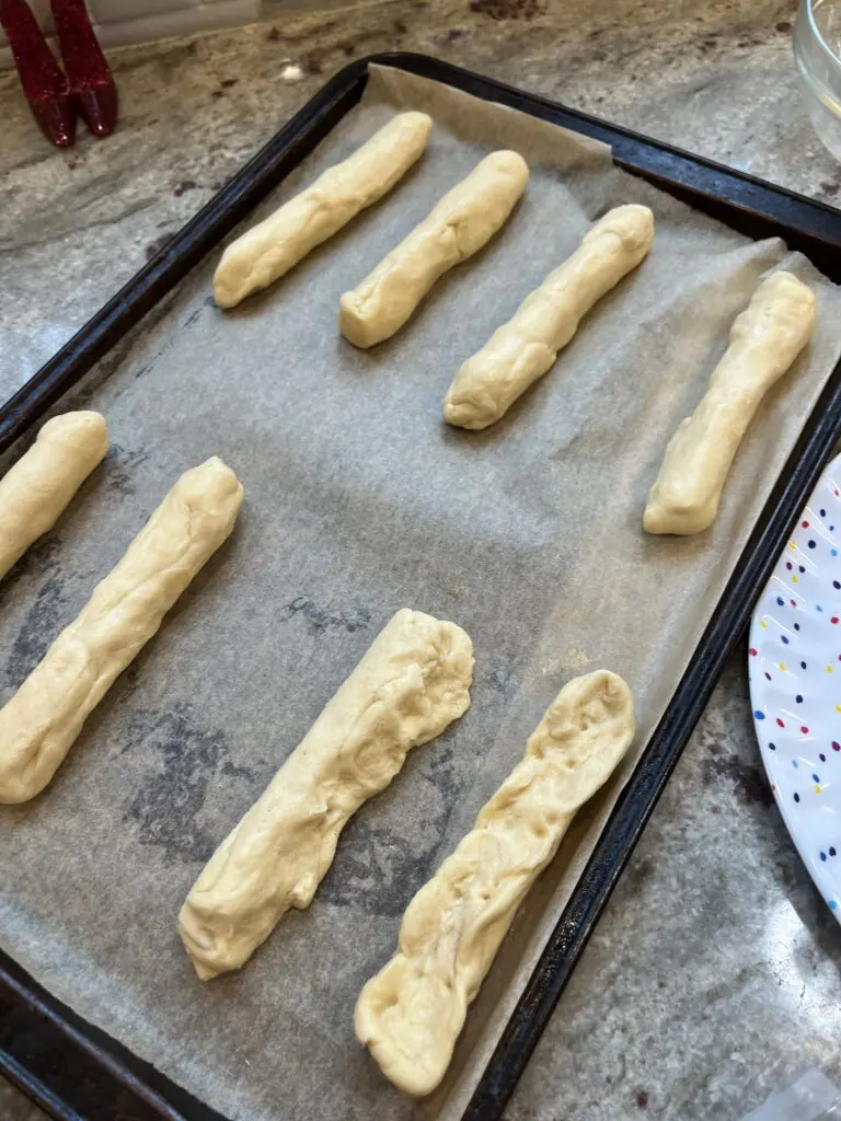 string cheese wrapped crescent rolls spread out on baking sheet
