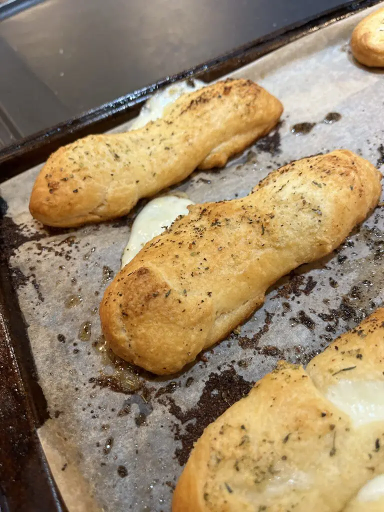 cheese stuffed bread sticks on baking sheet