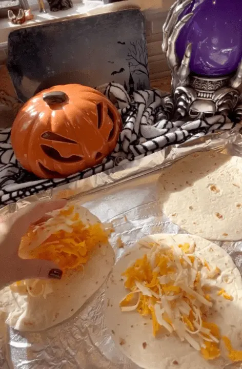 putting shredded cheese on the tortillas