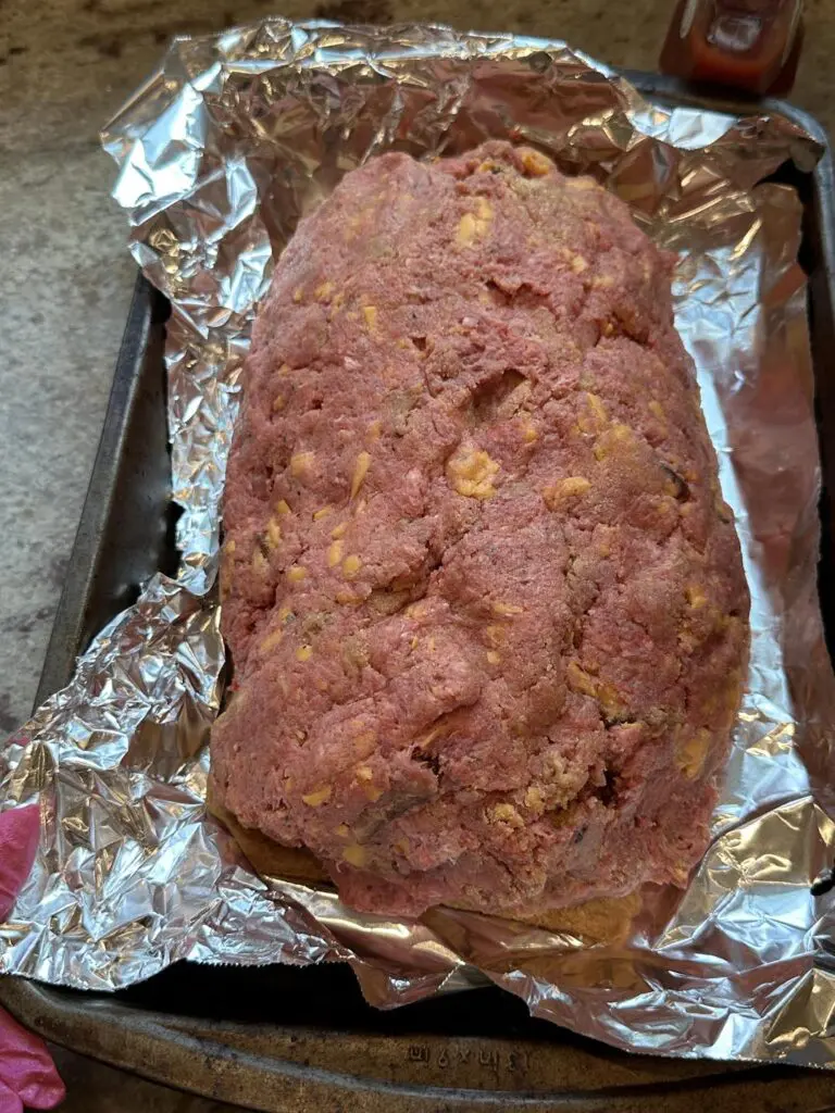 uncooked bacon cheeseburger meatloaf on baking sheet