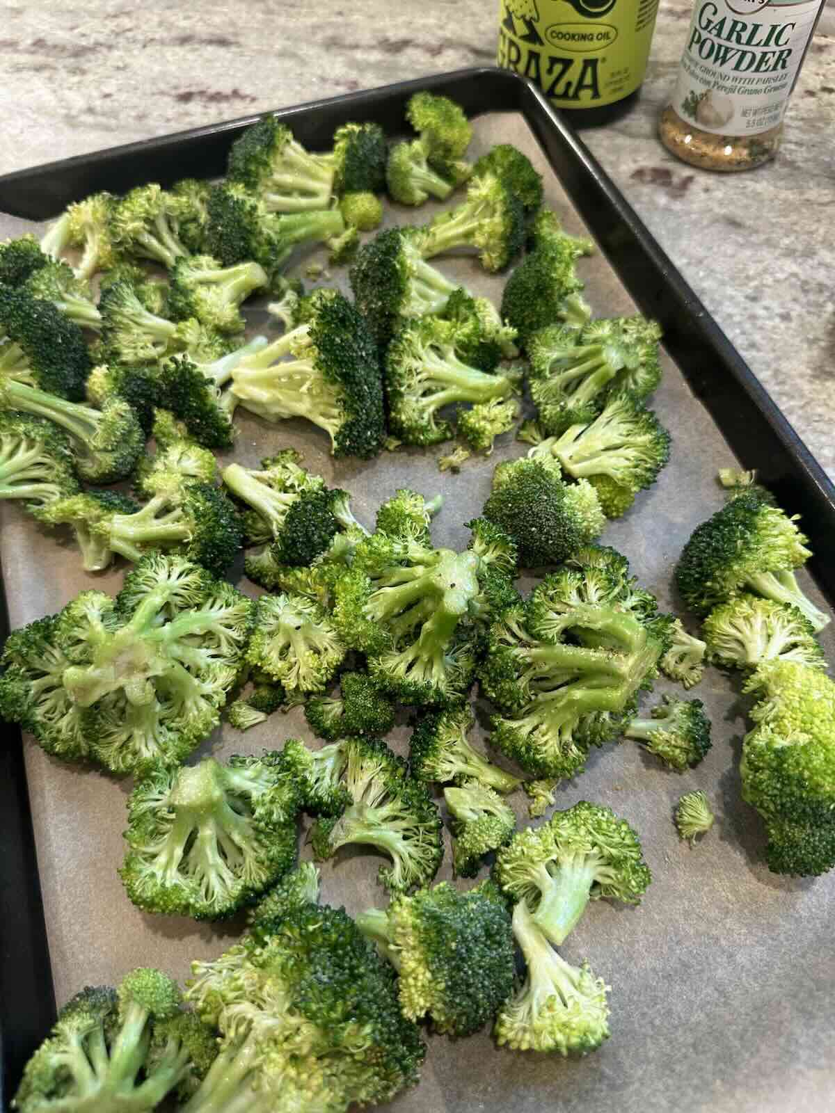 seasoned broccoli on baking sheet