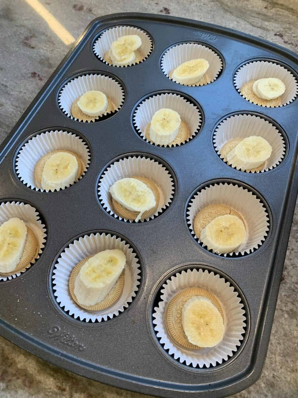 golden oreos in muffin tin with a slice of banana on top