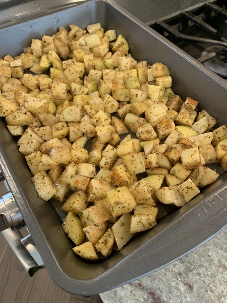 potatoes on a baking sheet ready for the oven