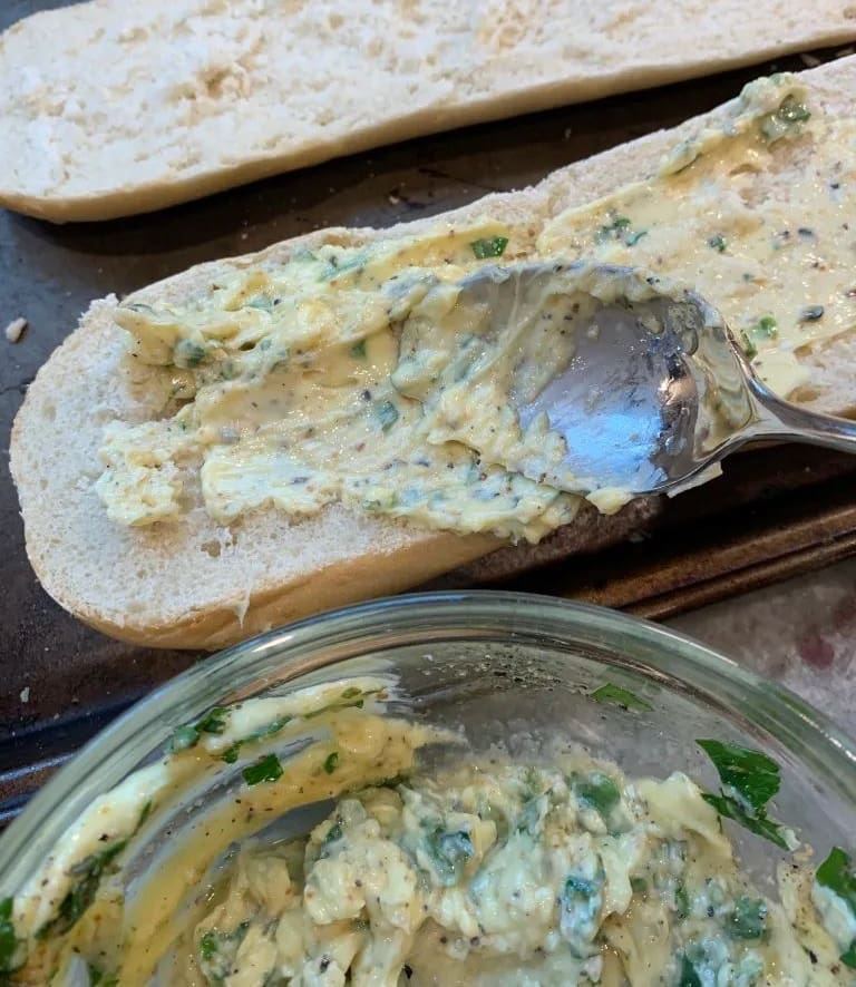 spreading butter on garlic bread