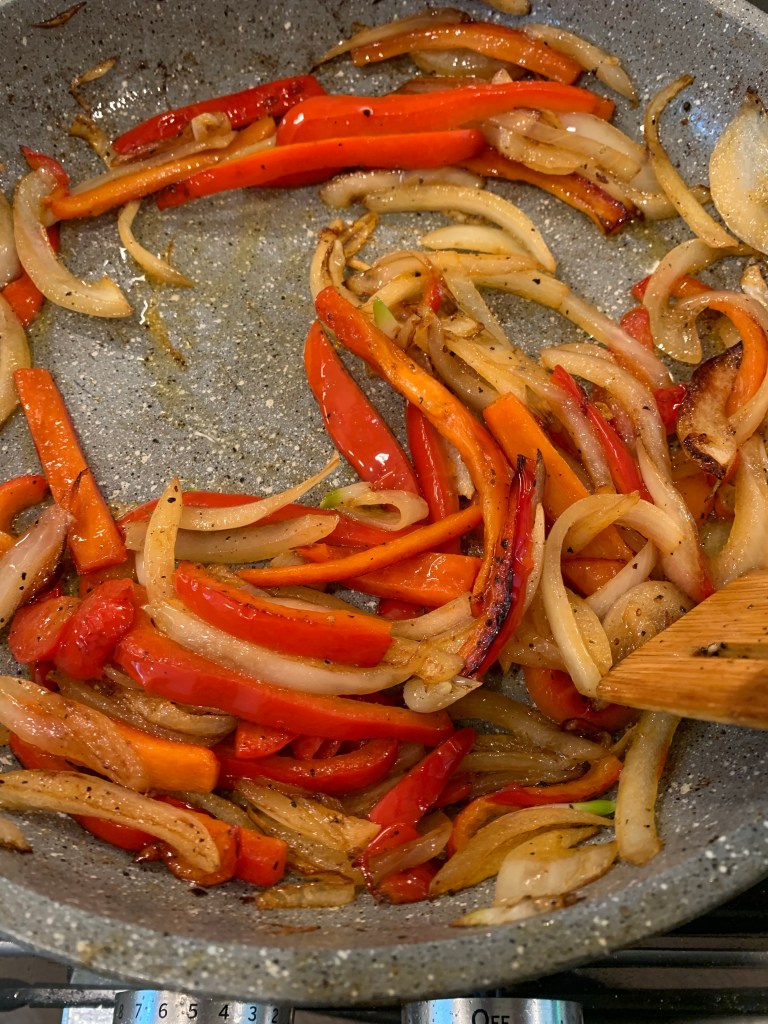 sautéed peppers and onions in skillet