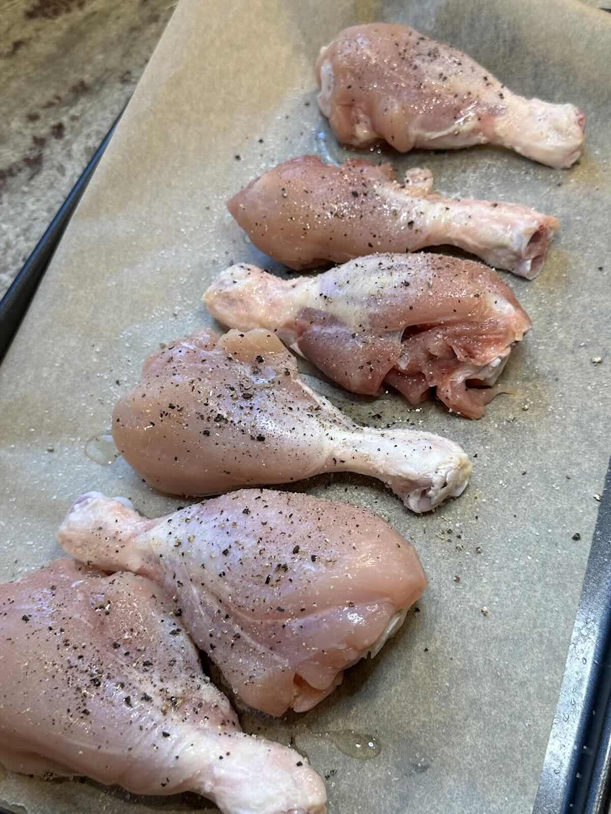 skinless chicken drumsticks on baking sheet