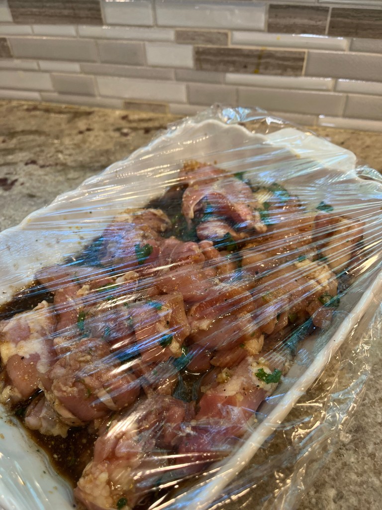 chicken in the marinade with plastic wrap