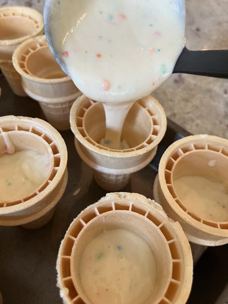 pouring cake mix into ice cream cones