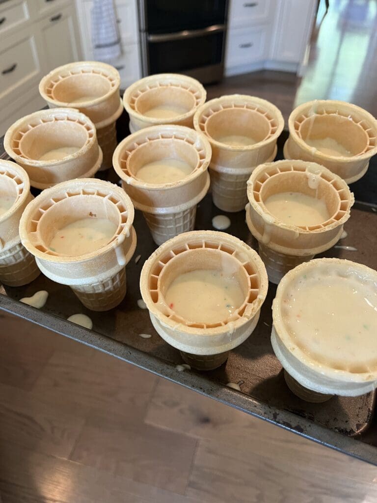 cake batter in ice cream cones on baking sheet