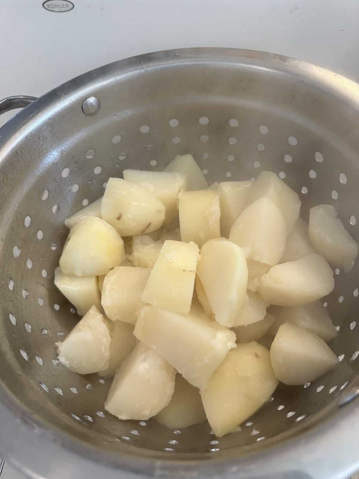 boiled potatoes being strained