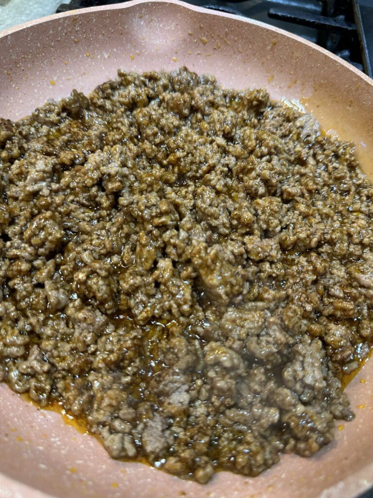 seasoned ground beef cooking in pan