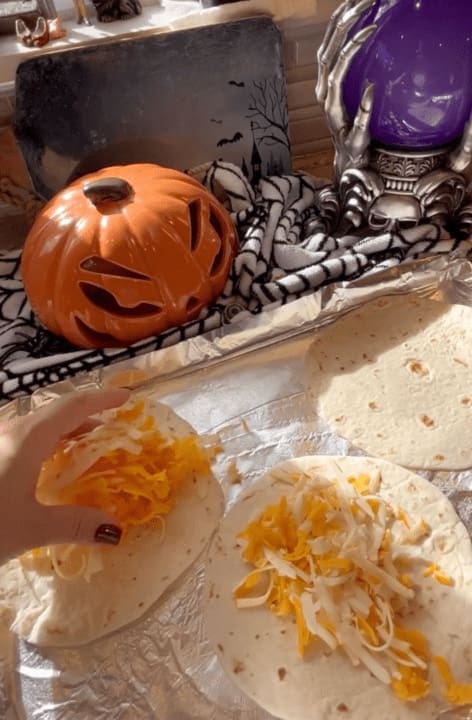 putting shredded cheese on the tortillas