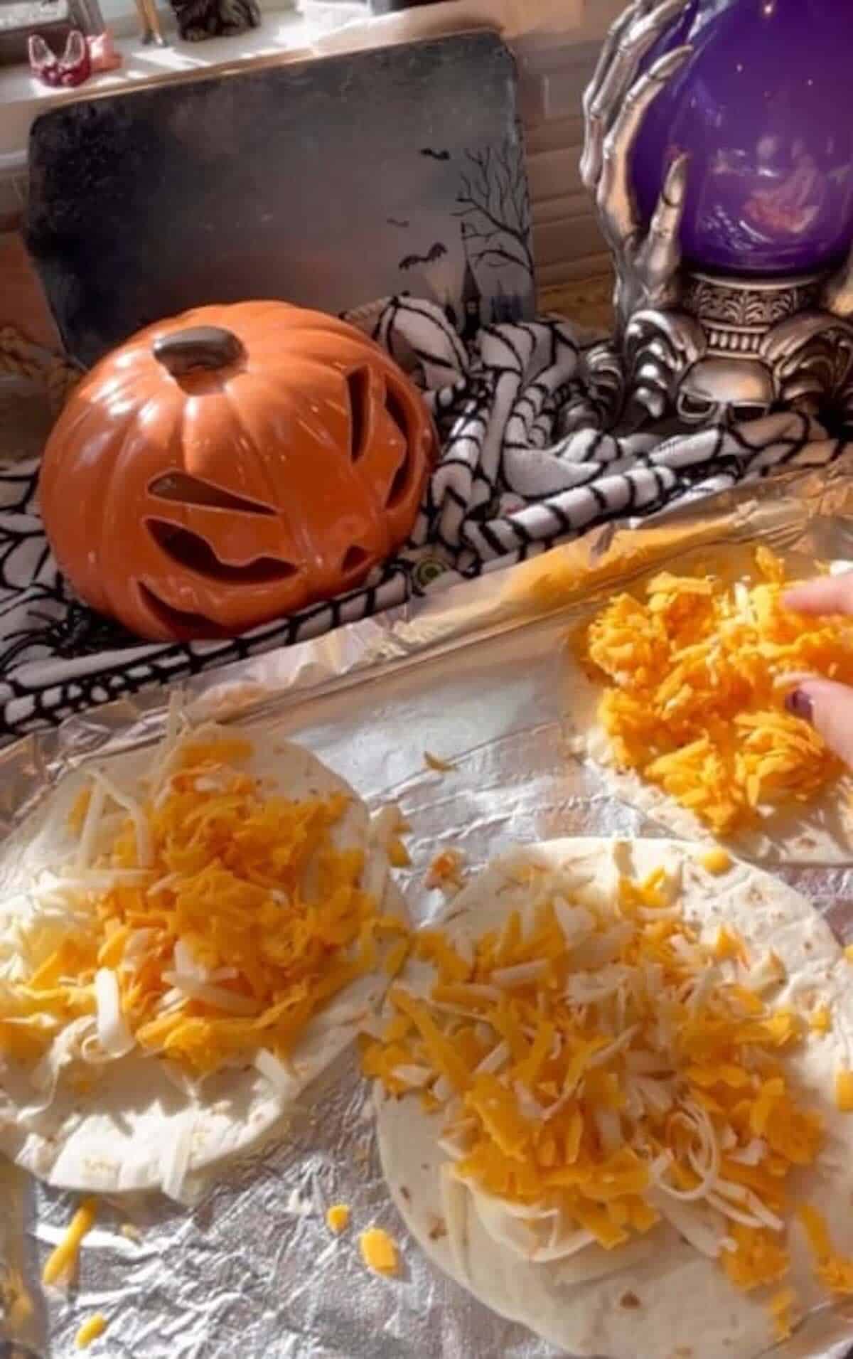 tortillas and cheese down on baking sheet