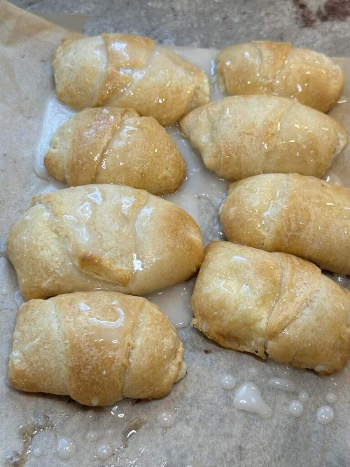 finished lemon cheesecake crescent rolls on baking sheet with glaze