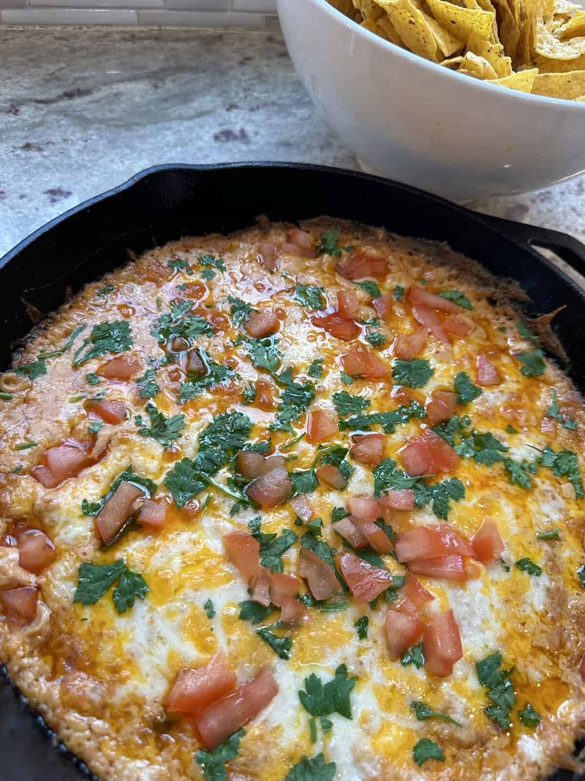 finished refried bean dip in cast iron skillet