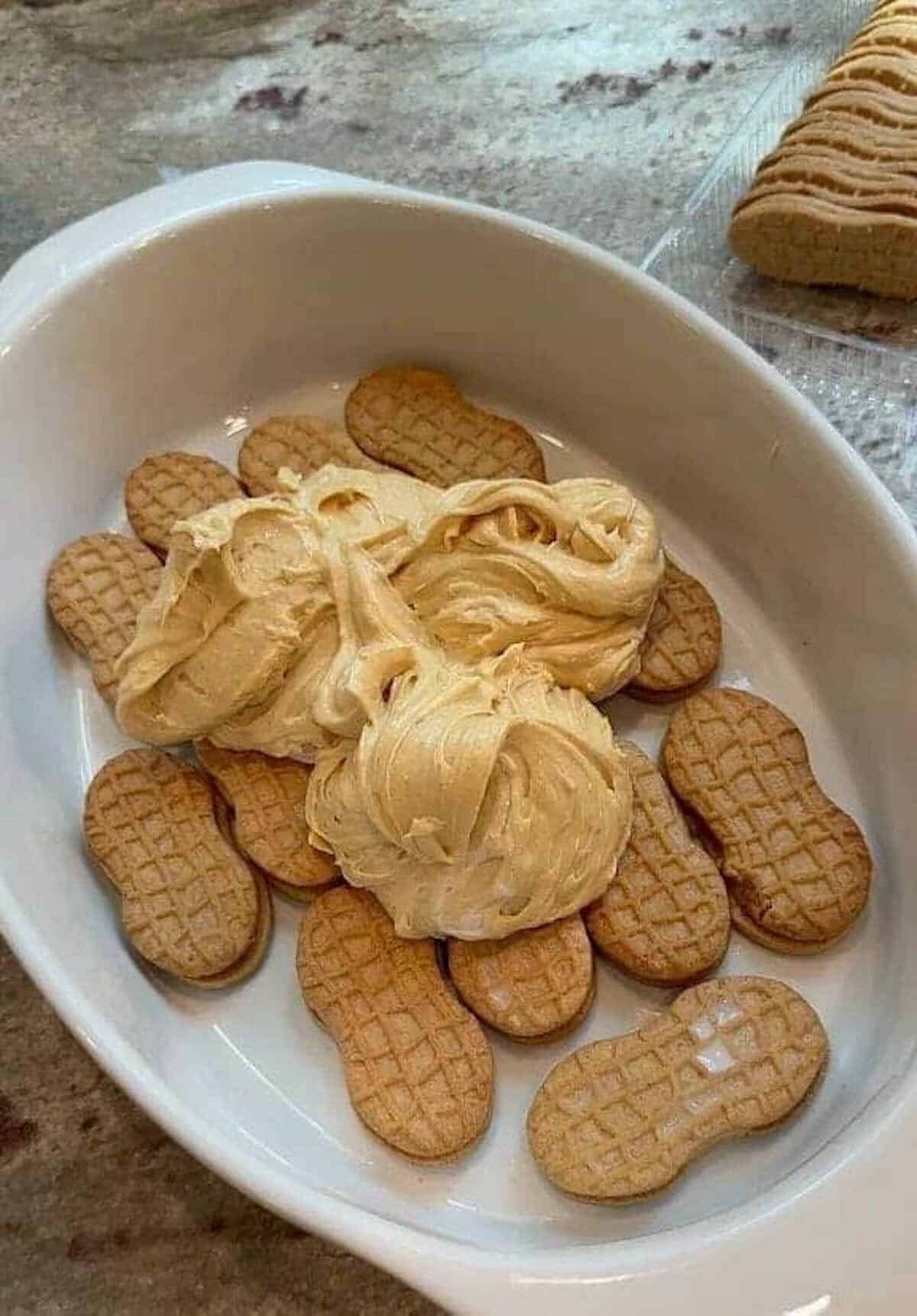 nutter butter cookies dunked in milk and topped with peanut butter pudding