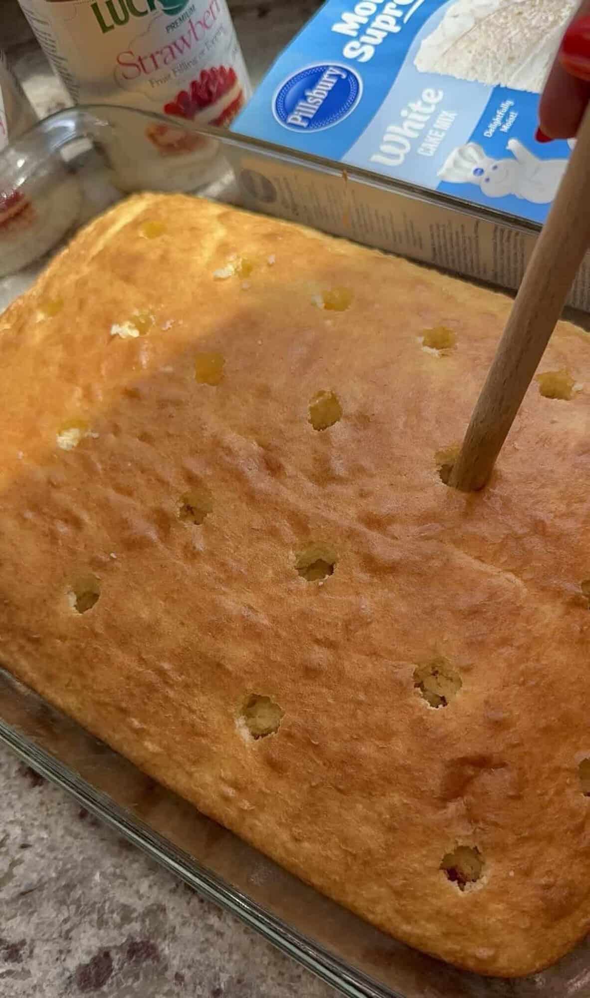 white cake mix cooled with holes poked into it