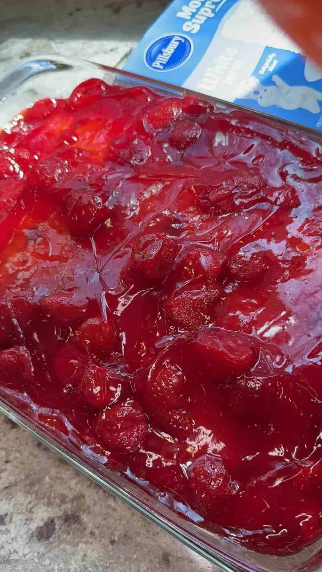 strawberry pie filling spread on top of white cake mix