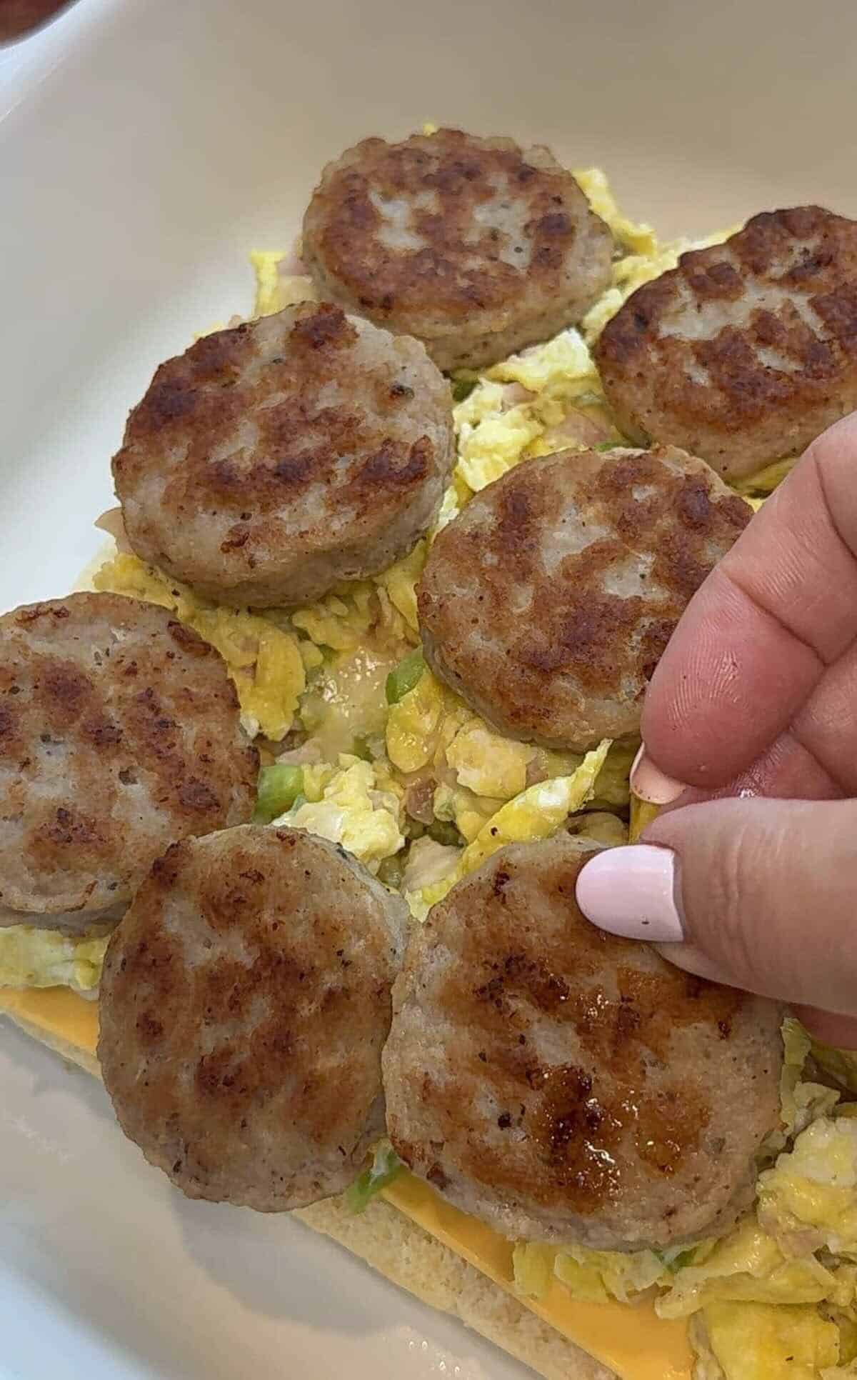 cooked sausage patties goin onto scrambled eggs