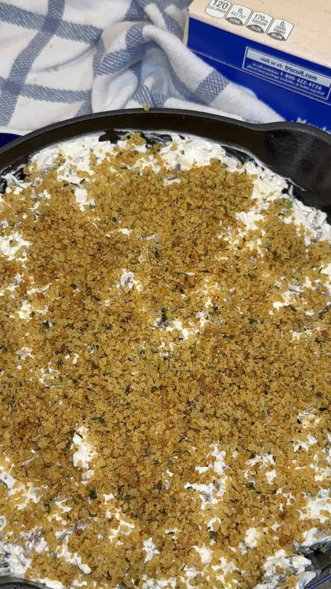 stuffed mushroom dip with sausage and breadcrumb topping in a skillet
