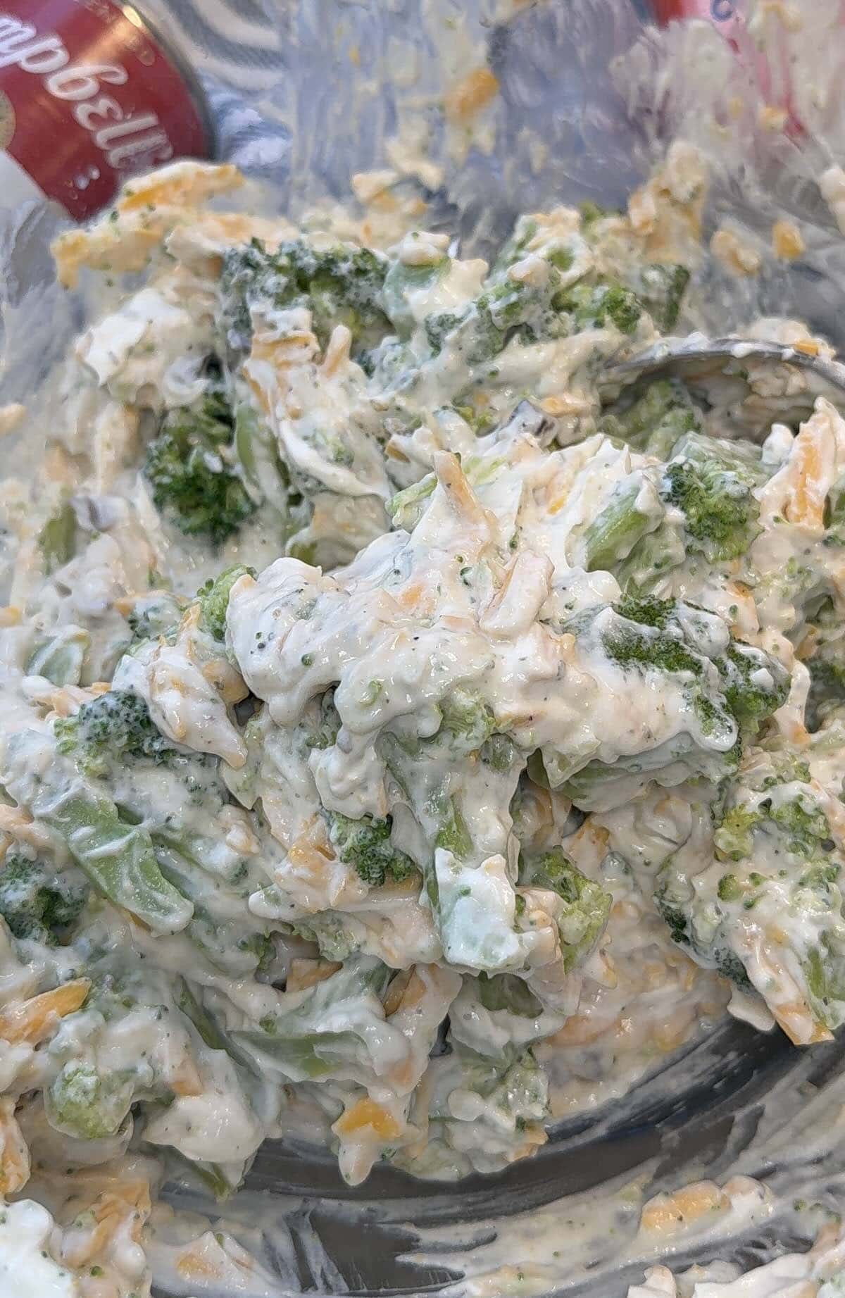 broccoli, onion dip and cheese mixed in a large bowl.
