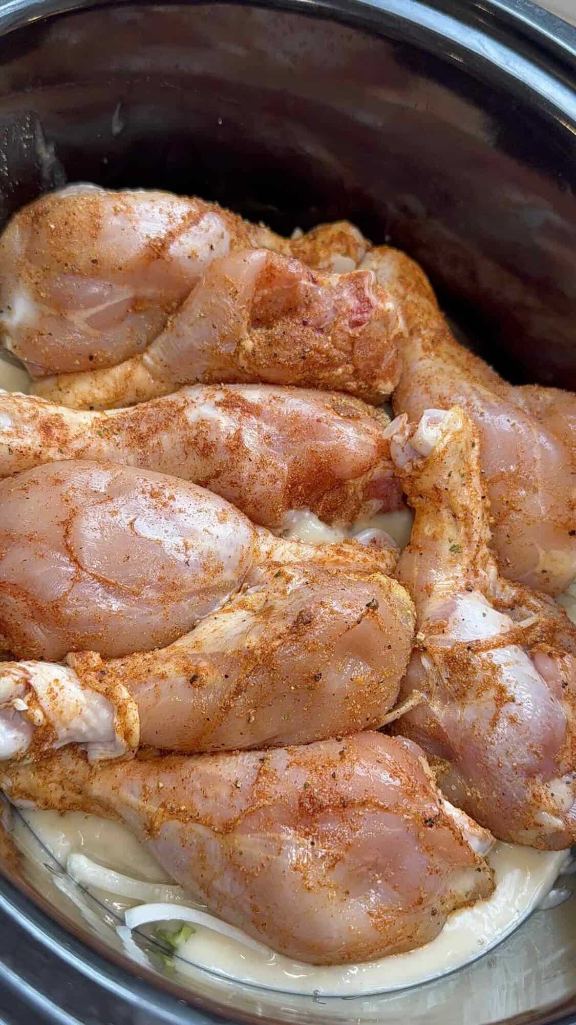 seasoned chicken over vegetables and gravy in crockpot