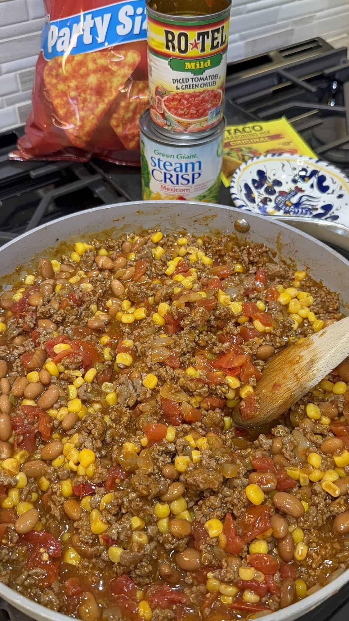 taco seasoned ground beef, rotel, enchilada sauce, corn and pinto beans in a large skillet.