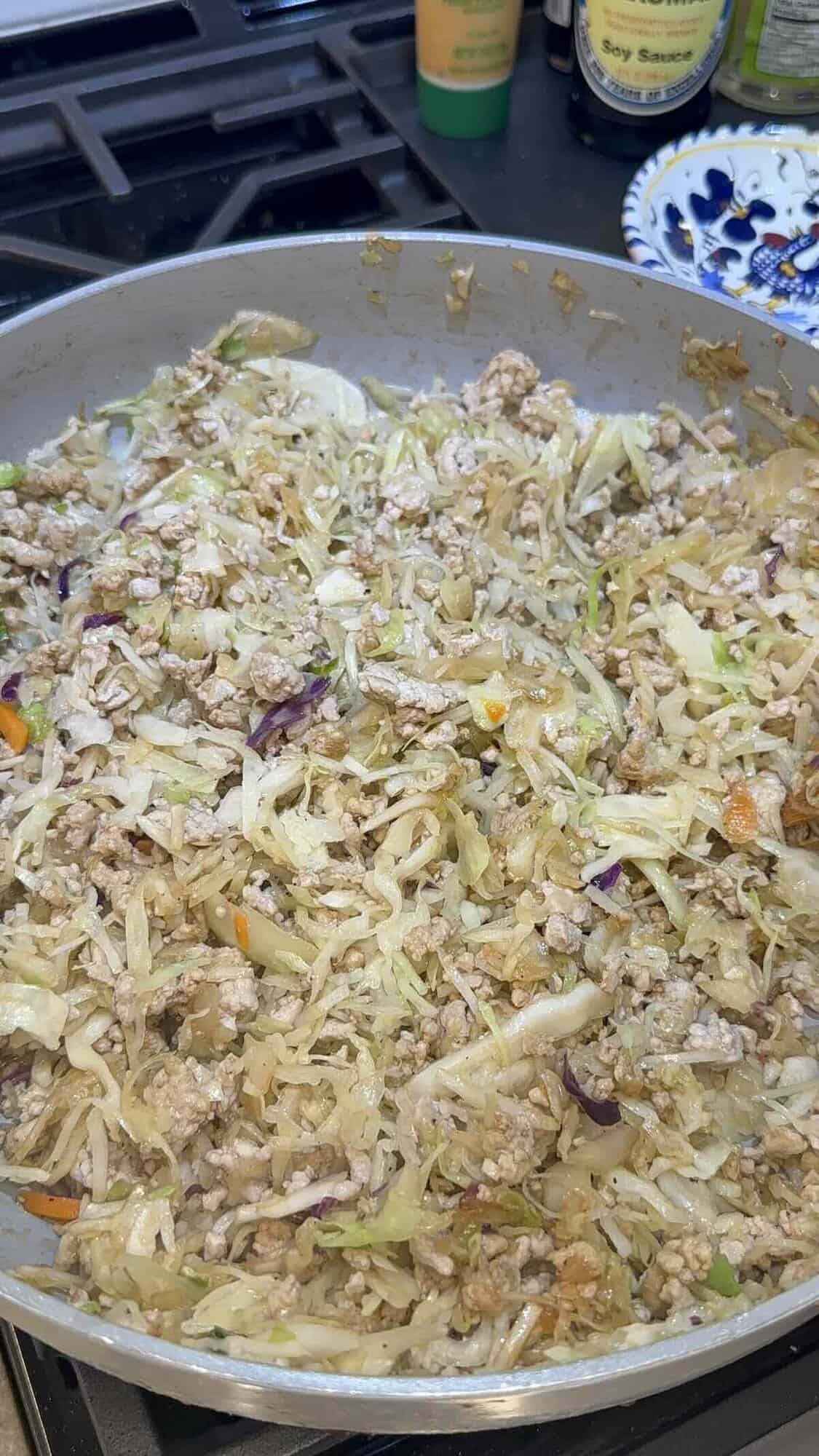 ground pork and coleslaw mix in a skillet