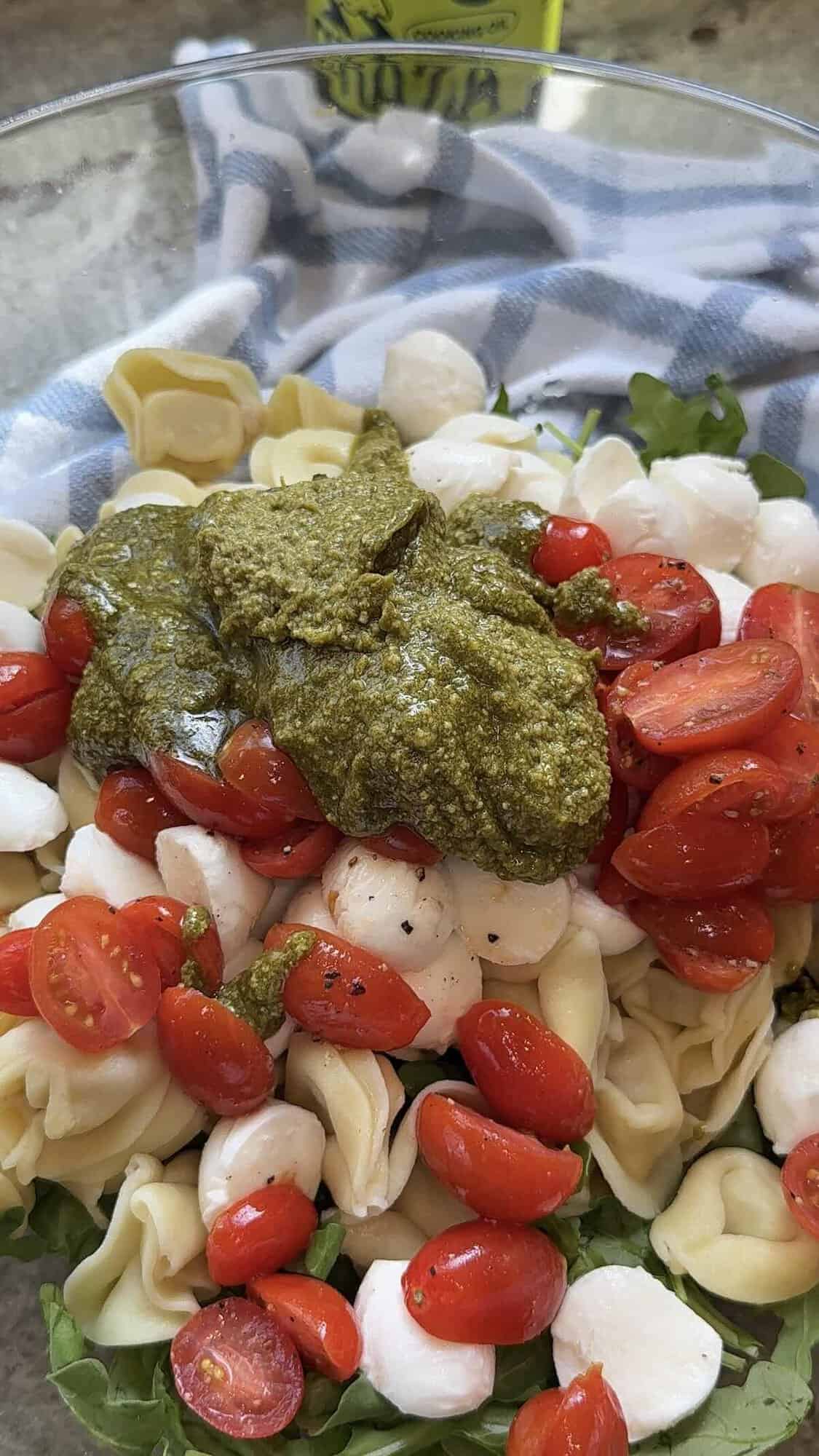 caprese pesto tortellini salad ingredients in a bowl