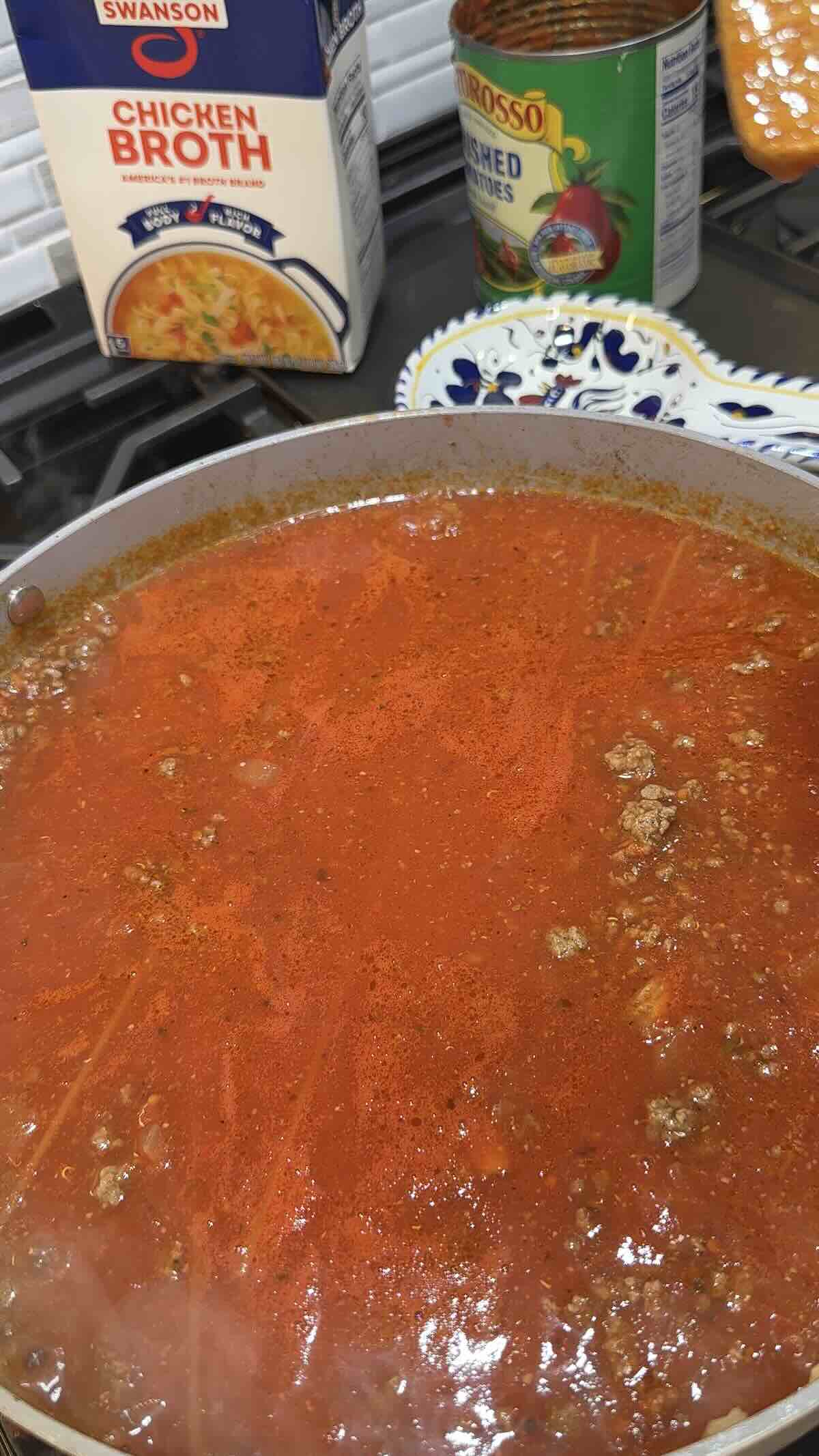 crushed tomatoes and chicken broth added to the skillet